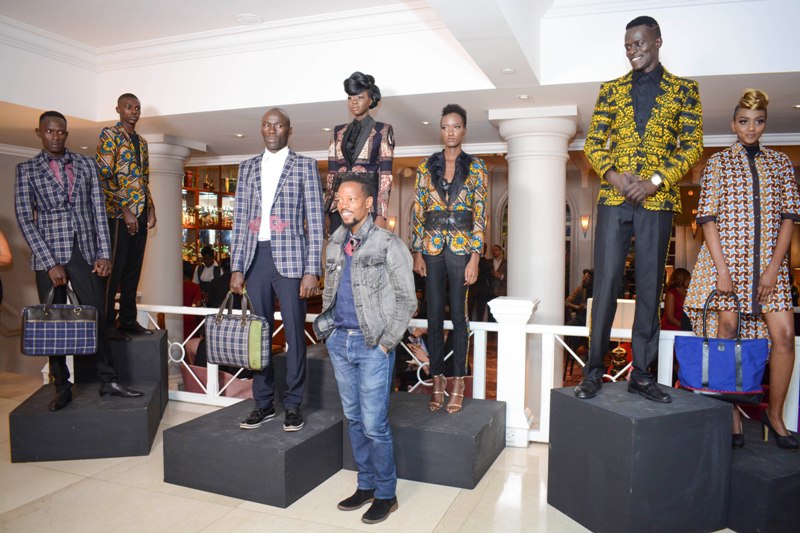 Fashion designer John Kaveke (front) models showcasing his designs.
